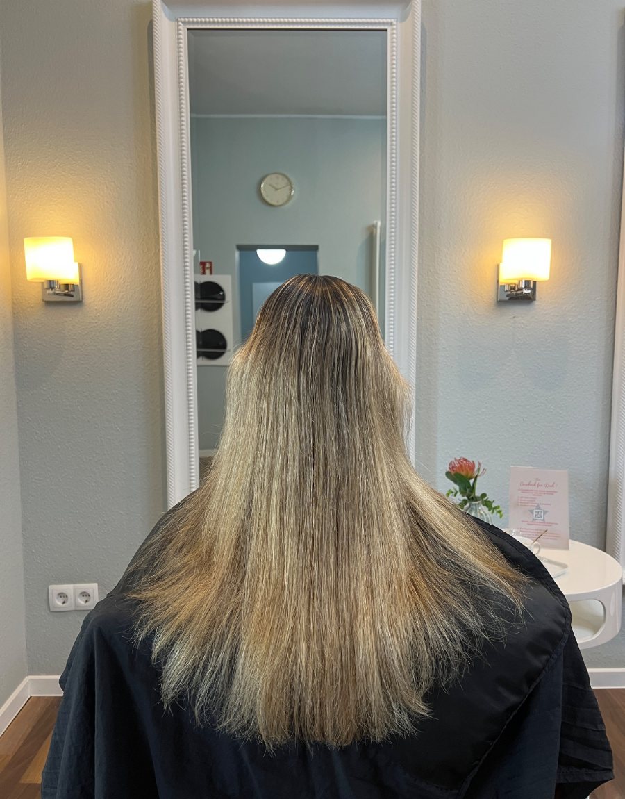 Lange, glatte blonde Haare mit Blumen im Hintergrund – Farbberatung