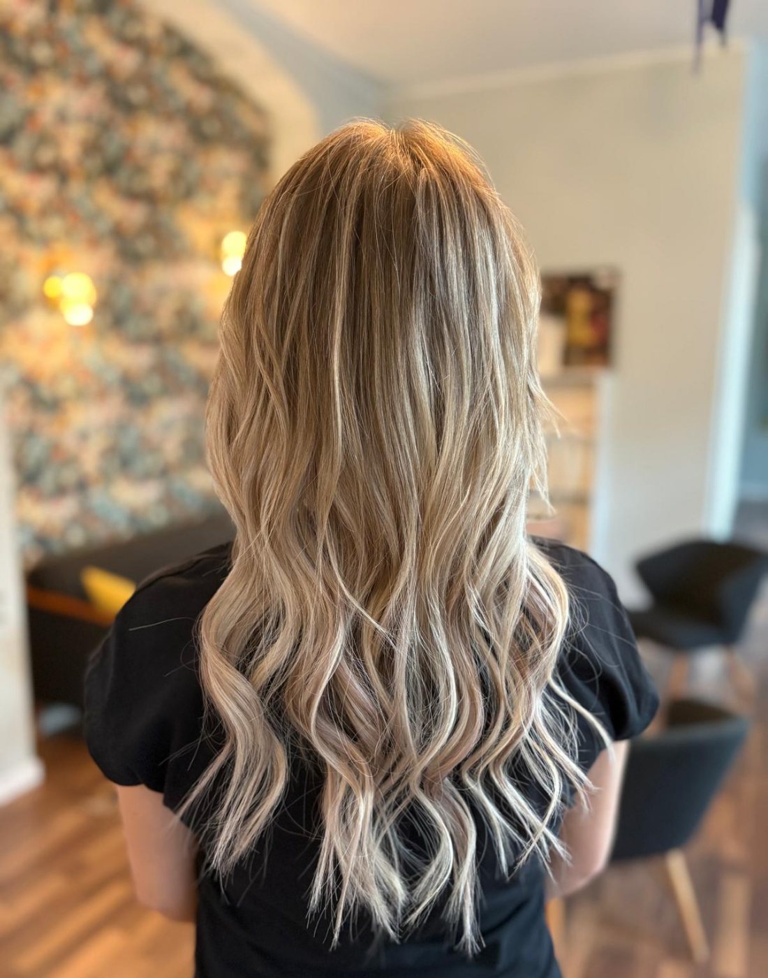 Lange, volle blonde Wellen nach einer Haarverlängerung mit Weft Extensions