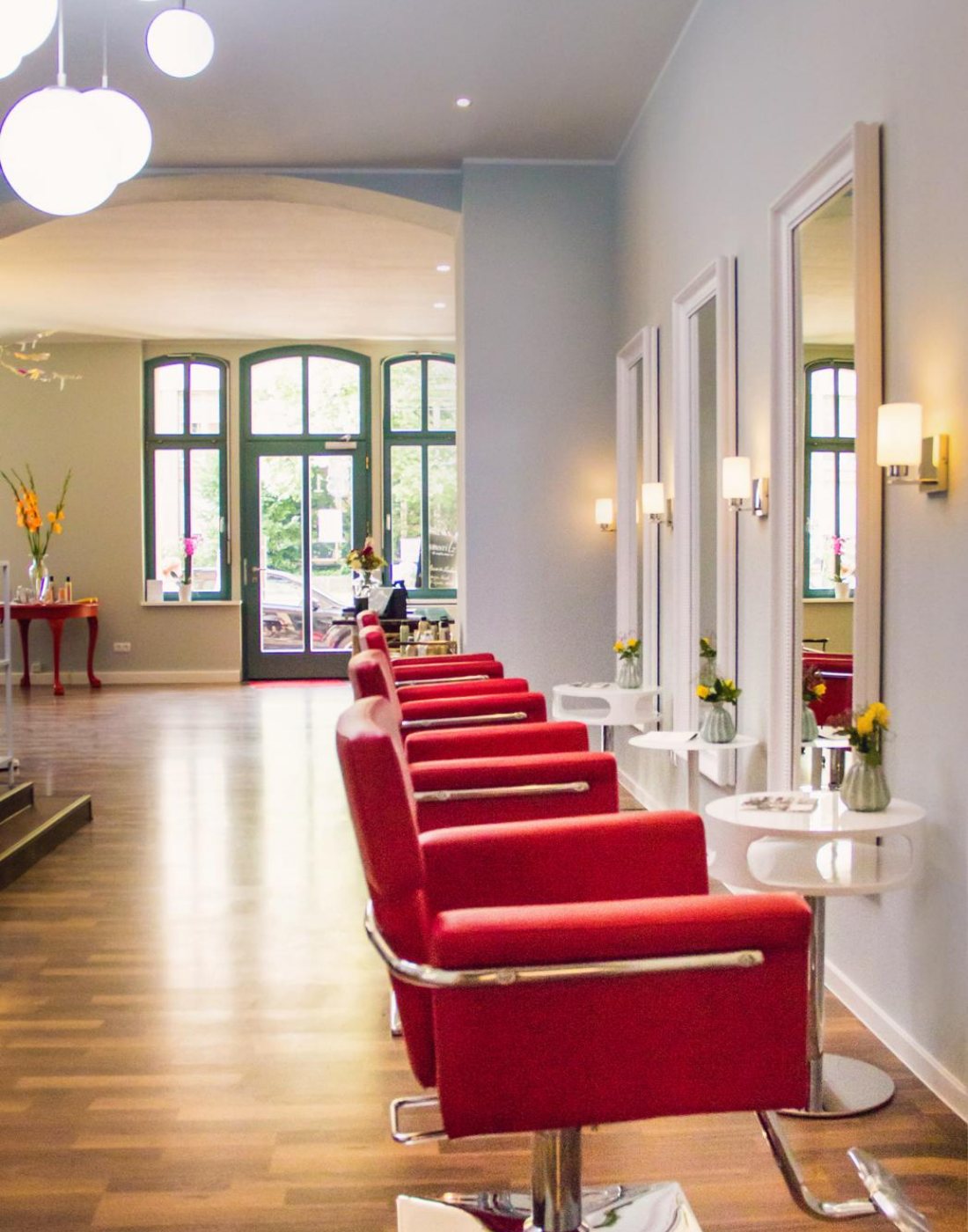 Der Salon von Miss Lilly’s: rote Sessel vor hohen Fenstern