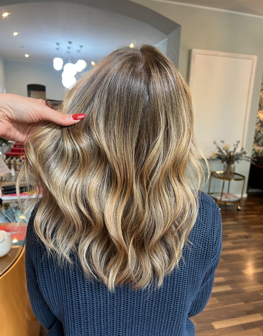 Glänzende blonde Wellen im Salon – Ergebnis einer persönlich geplanten Farbe